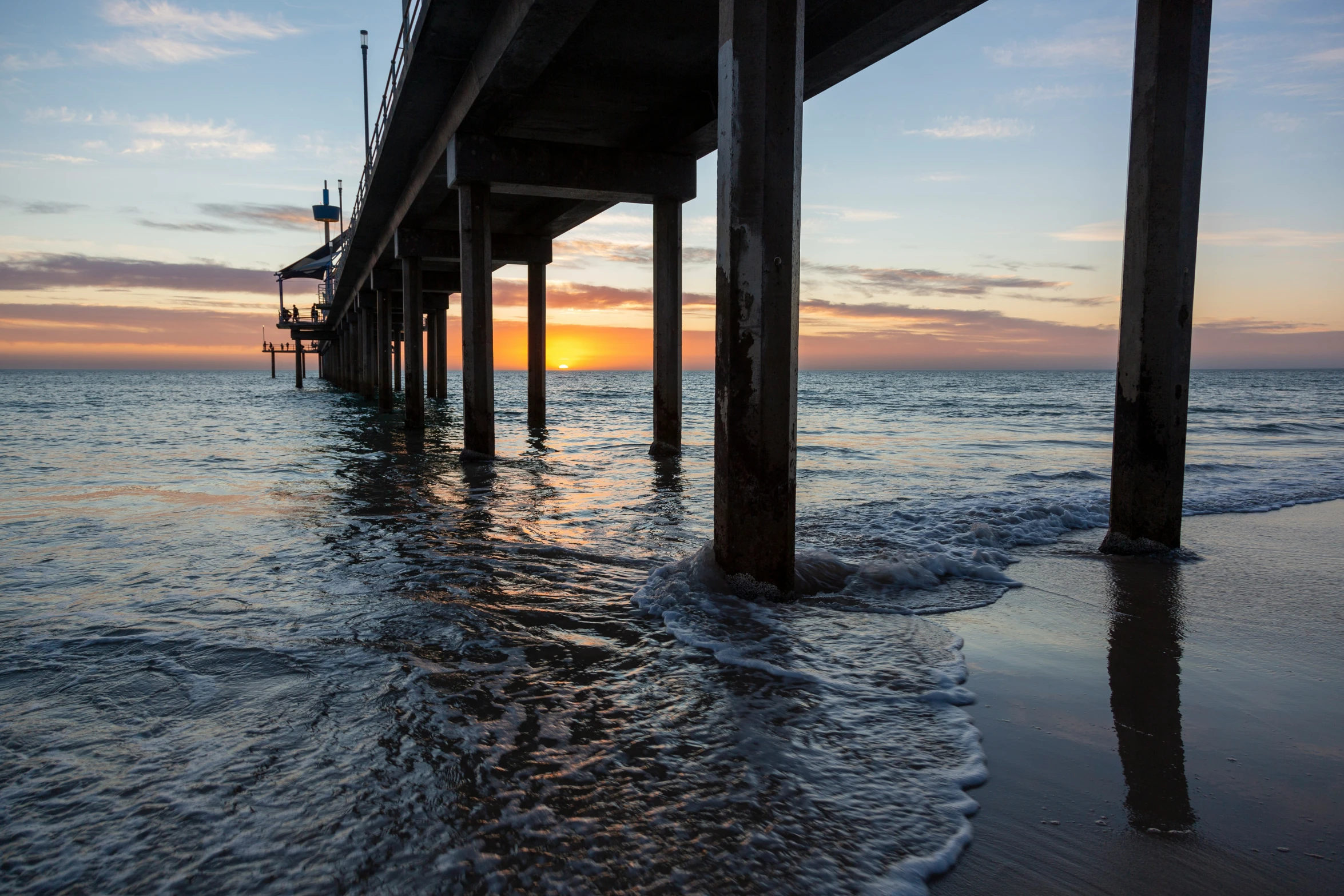 water under a pier that is almost calm