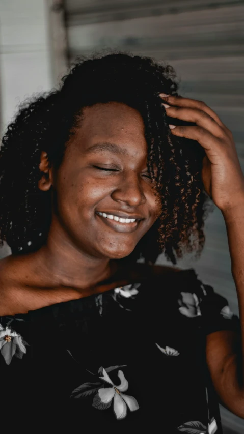 a woman smiling and holding her hair up