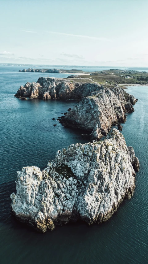 an aerial po of two rocky islands off of the ocean