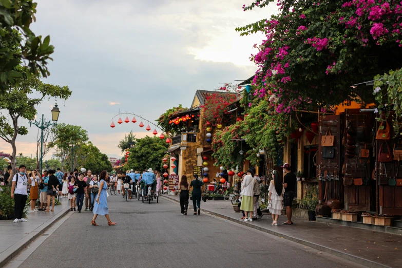 many people are walking down a street lined with buildings