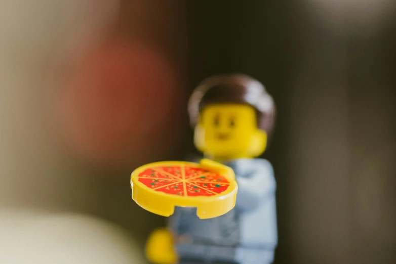 a lego man holding a slice of pizza