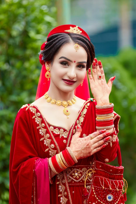 a bride in a red gown smiles while getting married