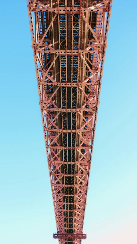 the view from below of a bridge with blue skies in the background