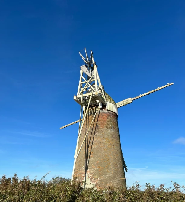 a large windmill is standing on top of the land