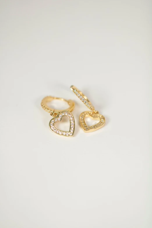 three gold earrings with hearts on top