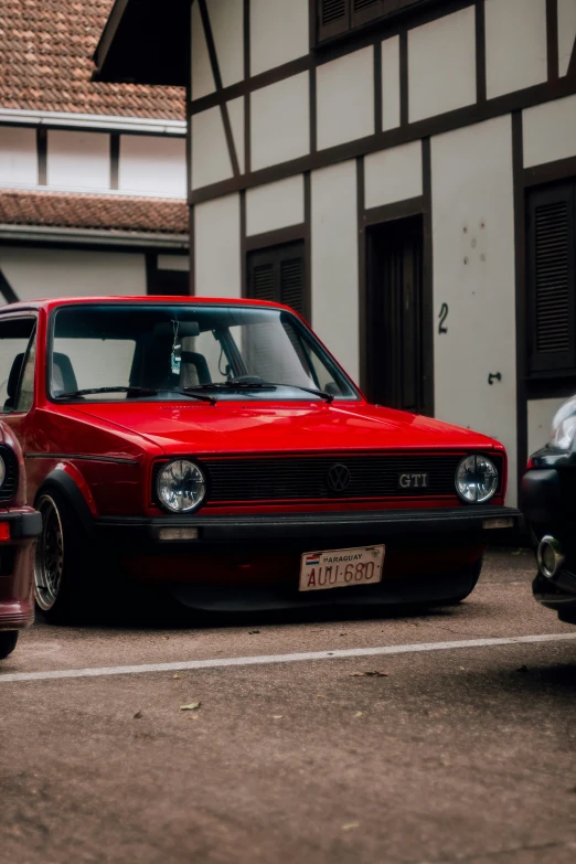 a red car parked next to a white and black building