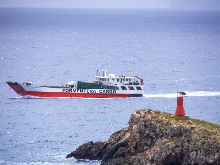 a ferry boat with a water gun passing by a red light