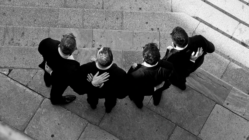 three businessmen standing on a sidewalk talking to each other