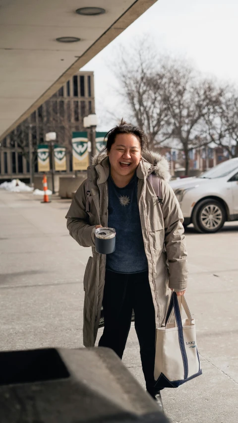 a woman walking down the street with a coffee cup in her hand