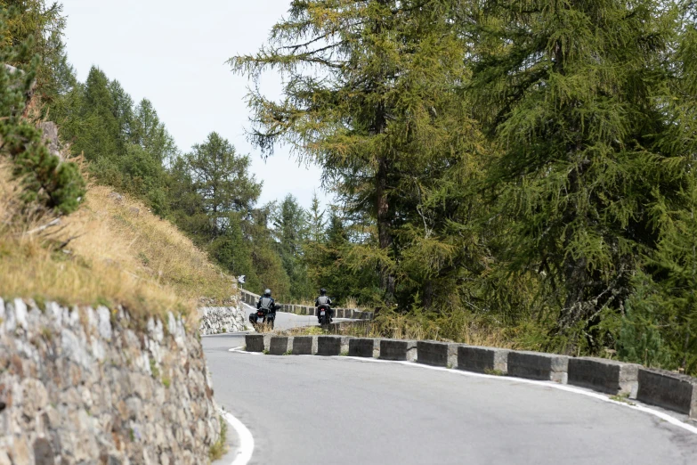 a man on a motor bike going down the road