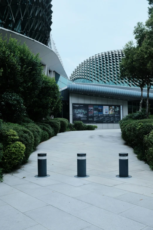 a building with a covered entrance and trees on either side of it