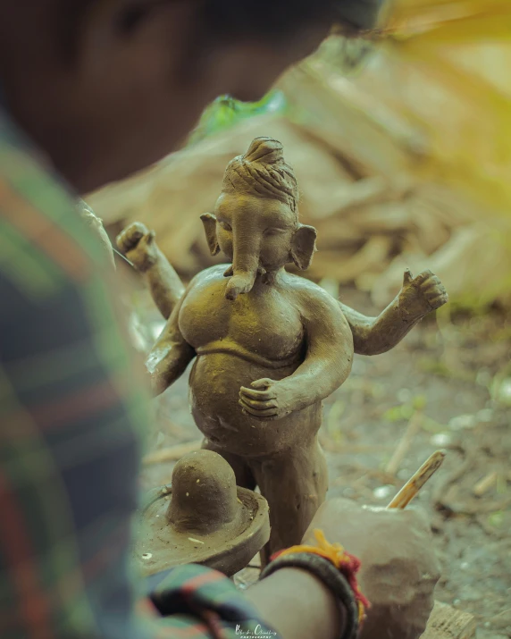 a man is putting sand into an ancient statue