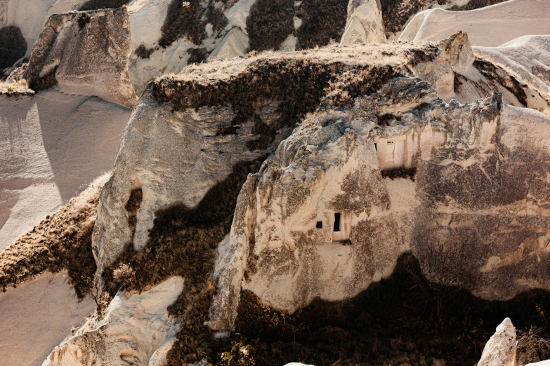 some large rocks that have a little house in the middle