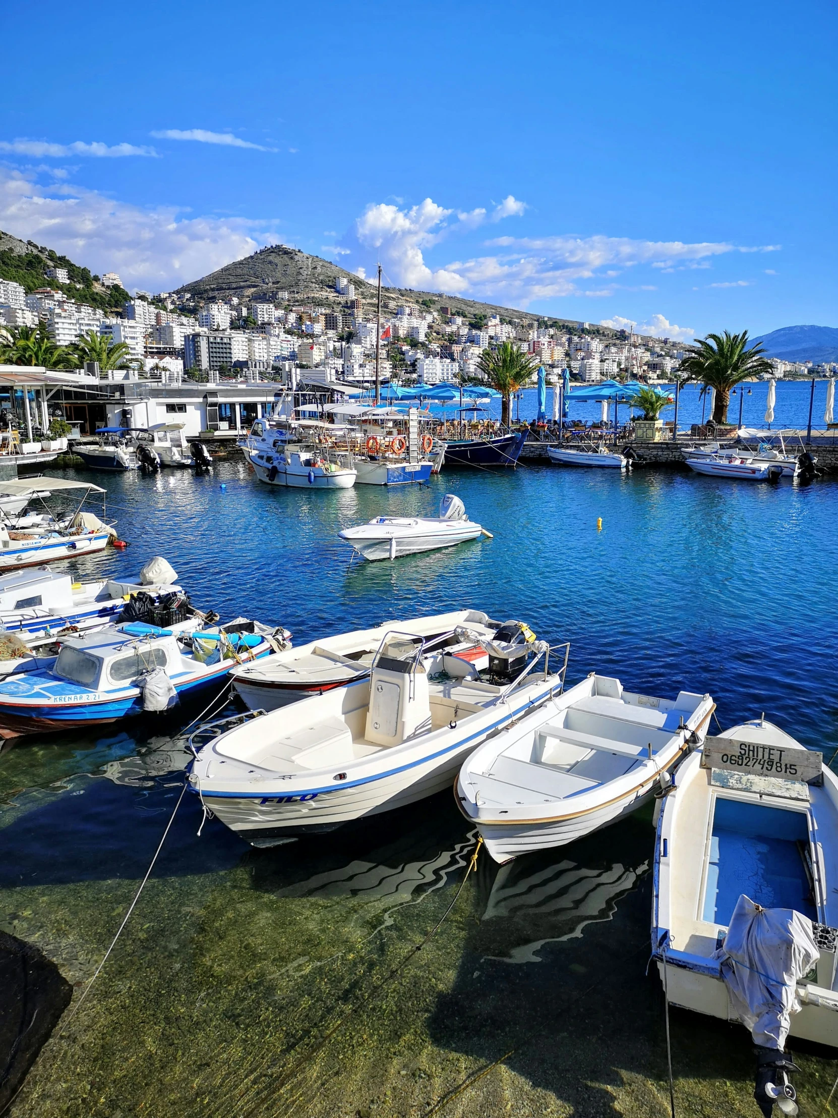 several boats docked on a water surface near the shore