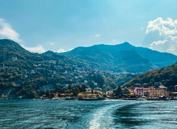 view of the town by the water with mountains in the background