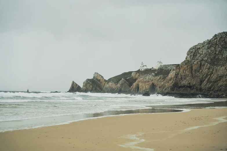 a beach with rocks and water by the sand