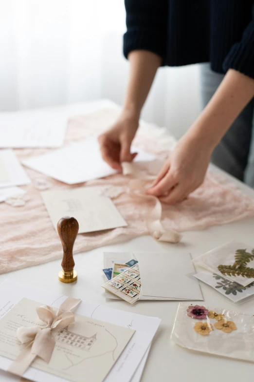 the hands of a woman embrows cards with rubber