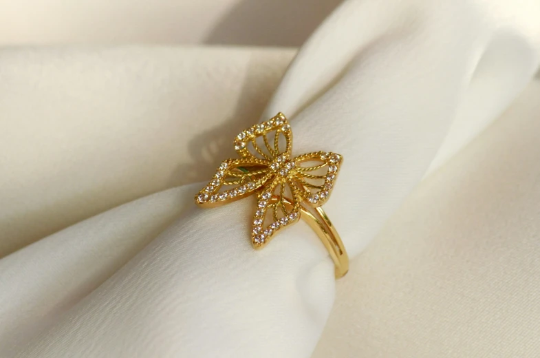 an elaborate ring has a golden leaf on it