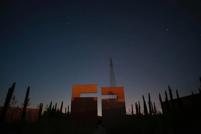 an cross sits between two tall brown buildings