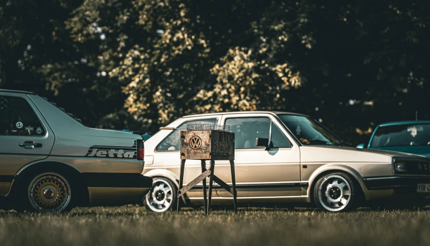 an old car and another car parked on the grass