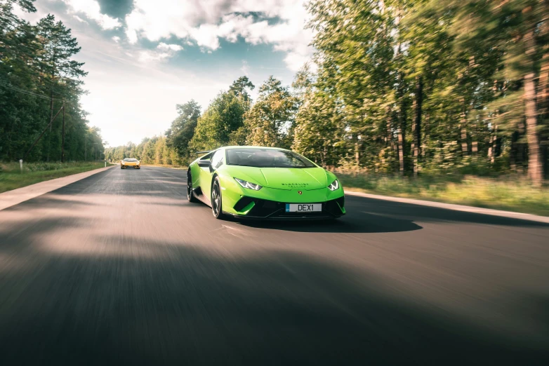 green sports car driving on the road during the day