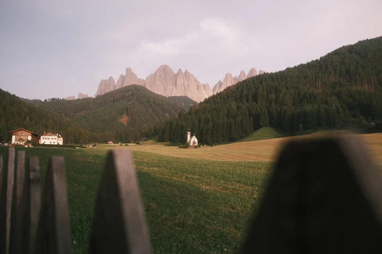 mountains behind a fence in front of some houses