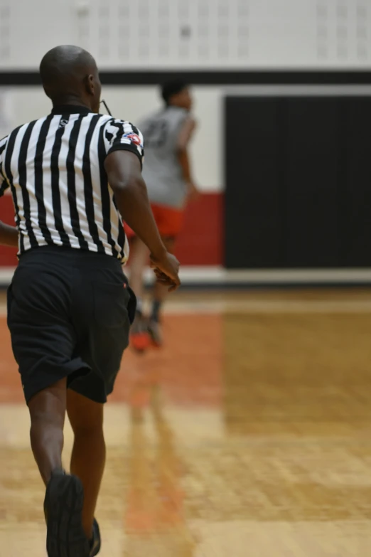 a man in the gym running and wearing shorts