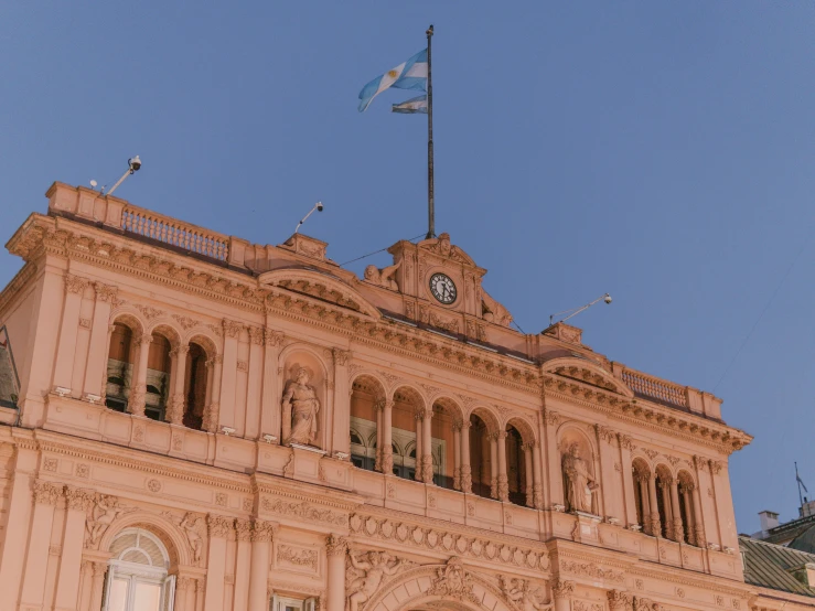 the clock tower on top of the building has an american flag flying from it