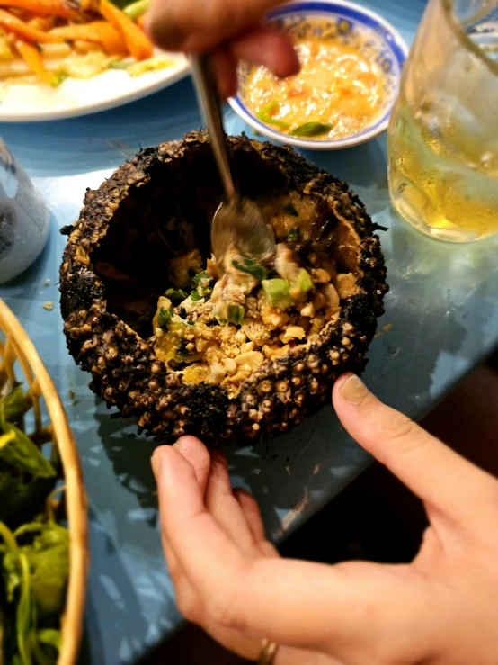 a person holding up a bowl of food next to some plates and bowls