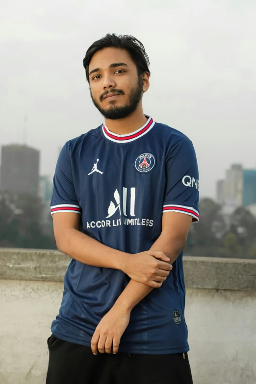 a man posing with his arms crossed outside