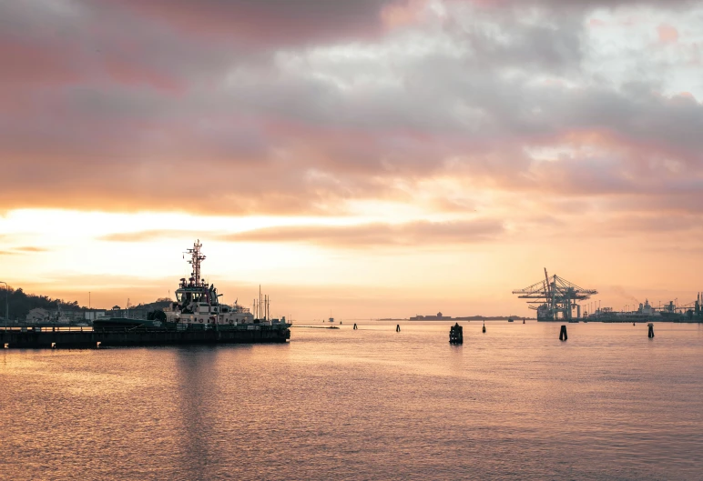 large boats floating in the water near an industrial port