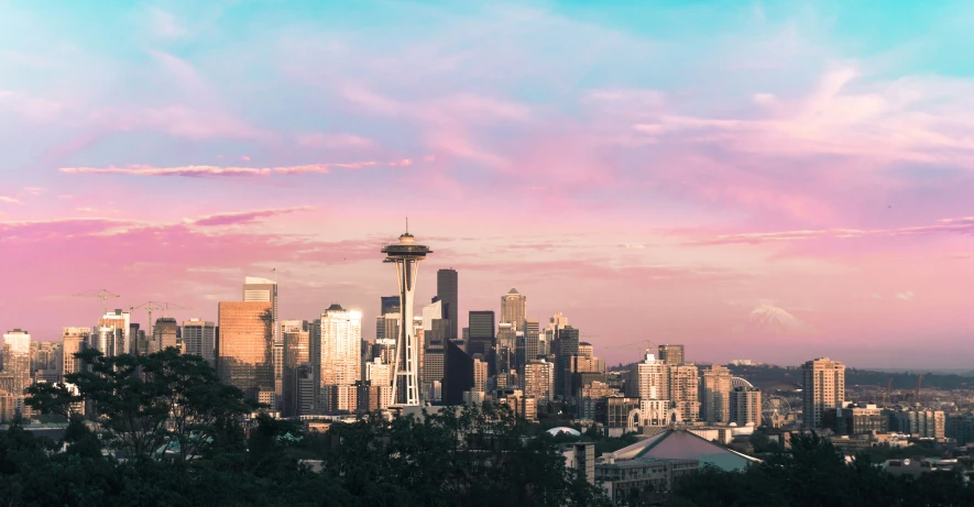 a city skyline from an elevated view with some colorful clouds