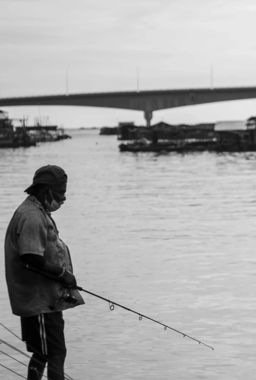 black and white po of a man holding a fishing rod