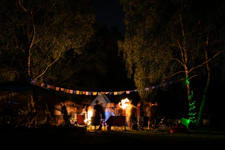 a number of people near a tent on a field