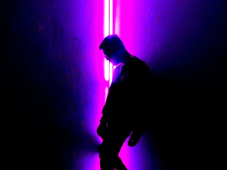 there is a male in the dark with a purple light