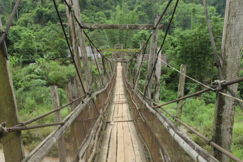 several old wooden and wire bridges with rope lines across