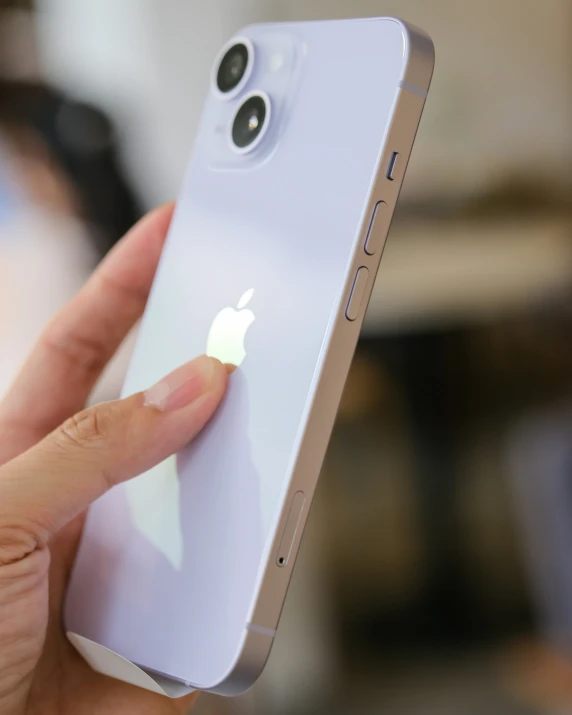 a person holds up an iphone with their finger