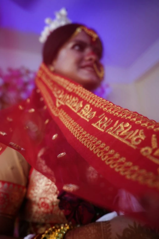 a bride wearing red and gold clothing