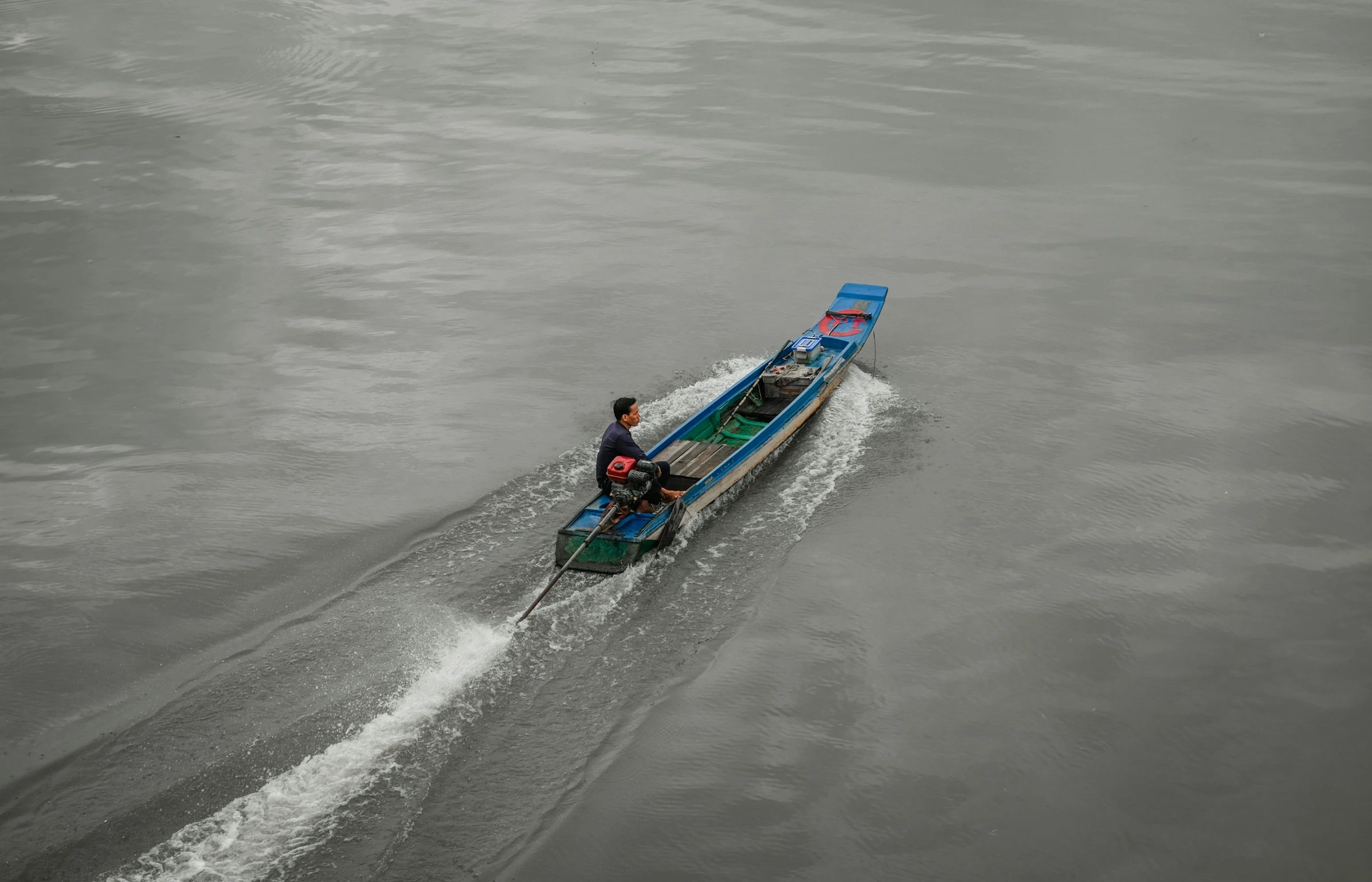 a person on a blue boat moving through the water