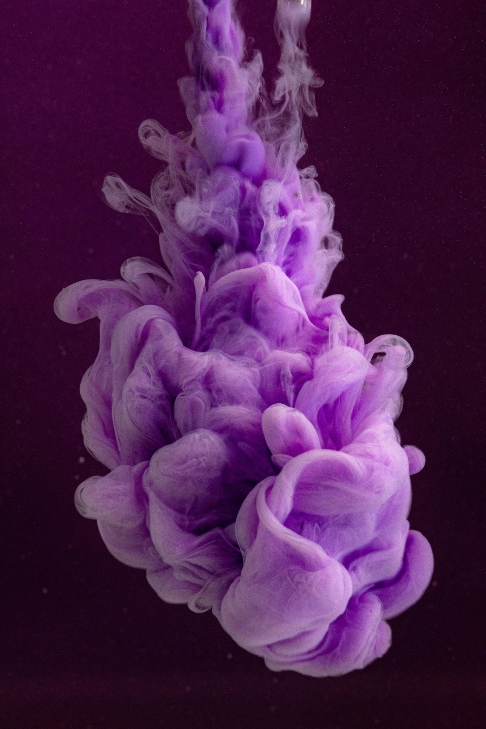 a purple substance floating in water with small bubbles