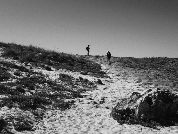 two people in silhouette standing on top of a hill