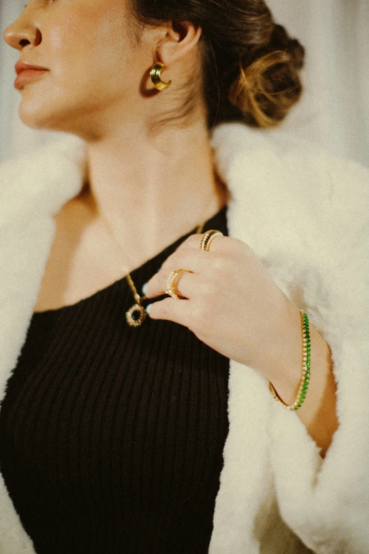 woman in black dress with green beaded celet and ring