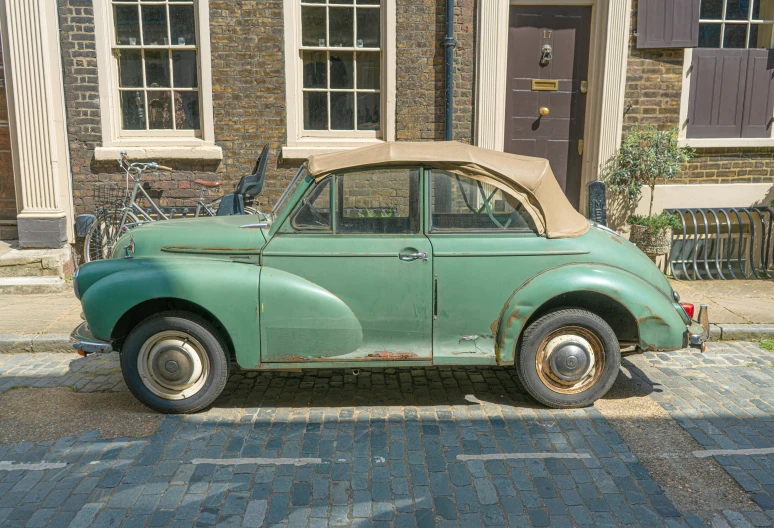 a vintage car on a cobblestone street