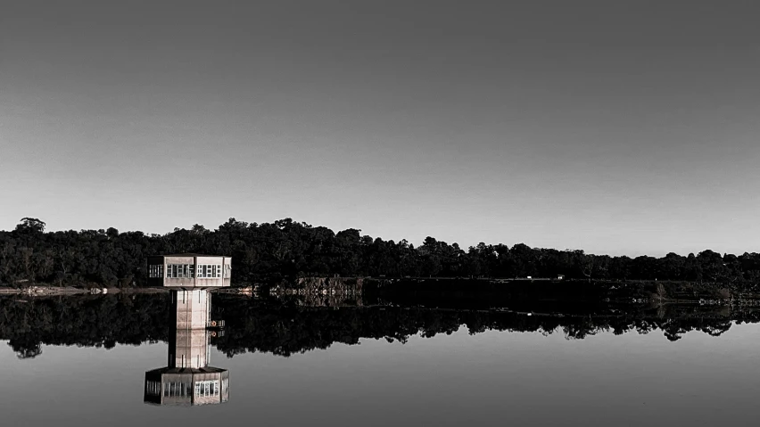 a small house is on the shore of a lake