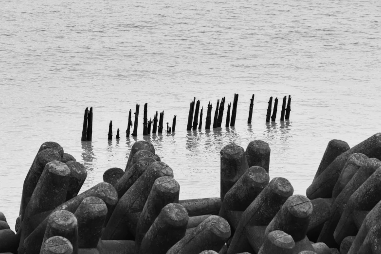 rocks are placed in the water by an old pier