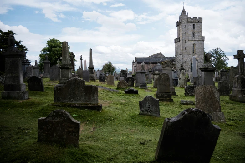 a cemetery has lots of graves and tall churches in it