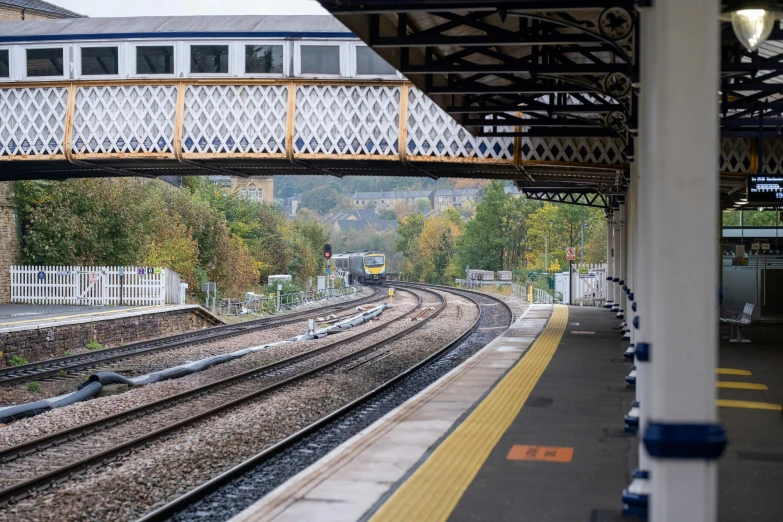 a bridge over a train track with some train cars going under it