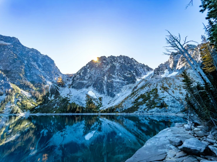 some snow mountains and a lake with water