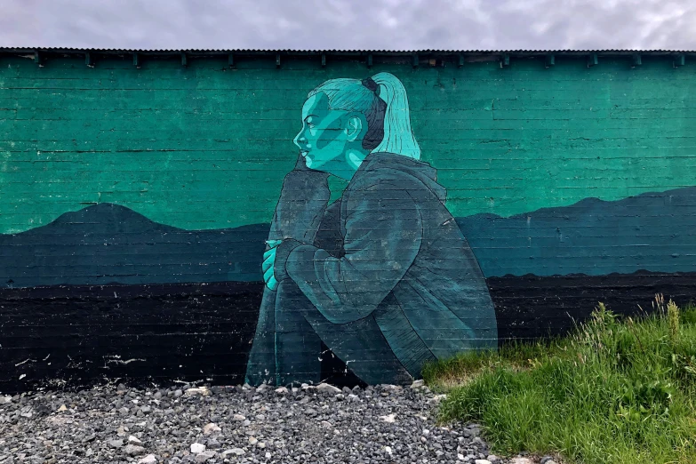 a painted brick wall depicting a person with blue hair