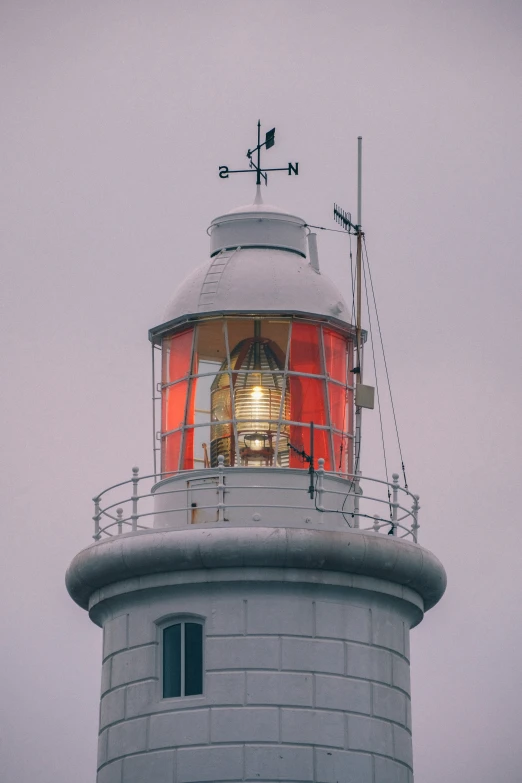 a view of a white lighthouse with an orange light